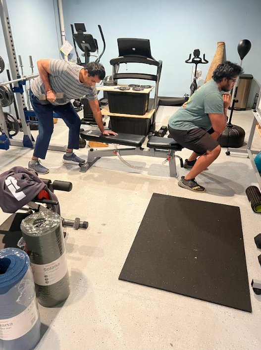 Coach Quez training clients in home gym setting